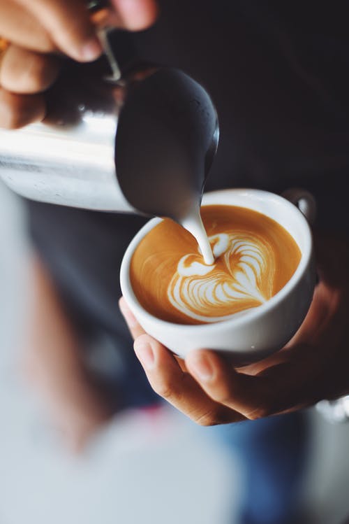 latte foam poured into cup making latte art