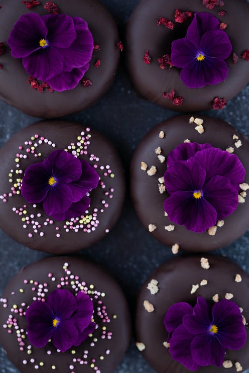 chocolate donuts with sprinkles and purple flowers