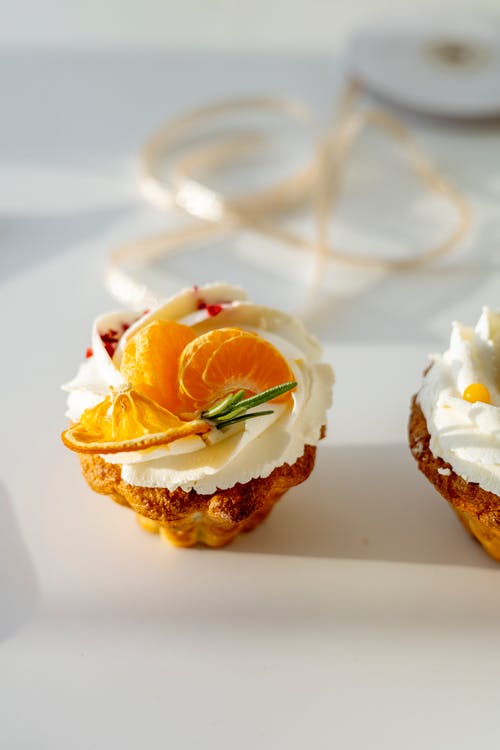 cupcake with vanilla icing and orange slice