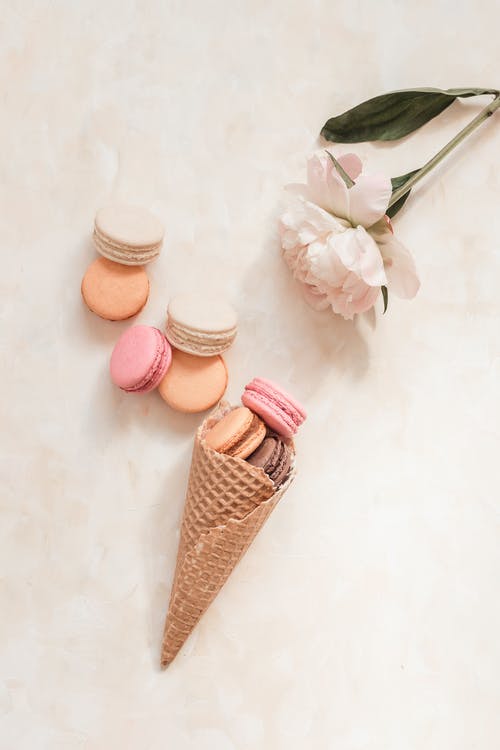 pastel macarons with white rose and waffle cone